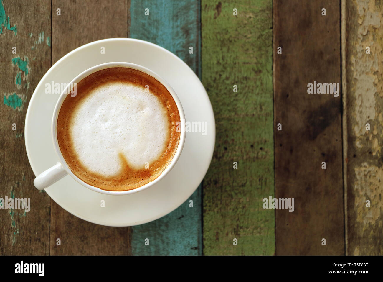 Blick von oben auf die heißen Kaffee mit Milchschaum in Herzform serviert auf rustikalen Holztisch Stockfoto