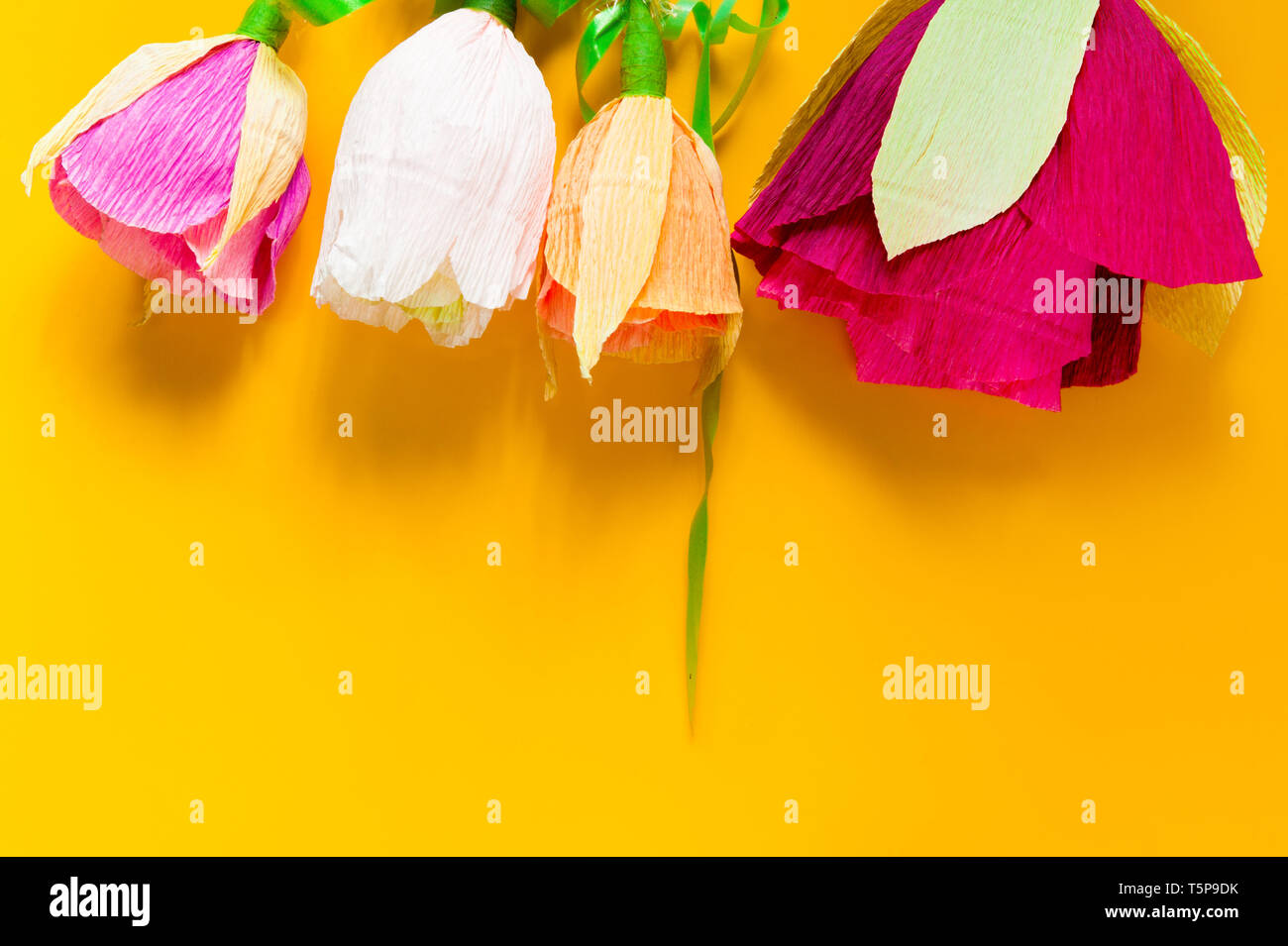 Hausgemachte Wellpappe Blüten auf gelbem Hintergrund Stockfoto