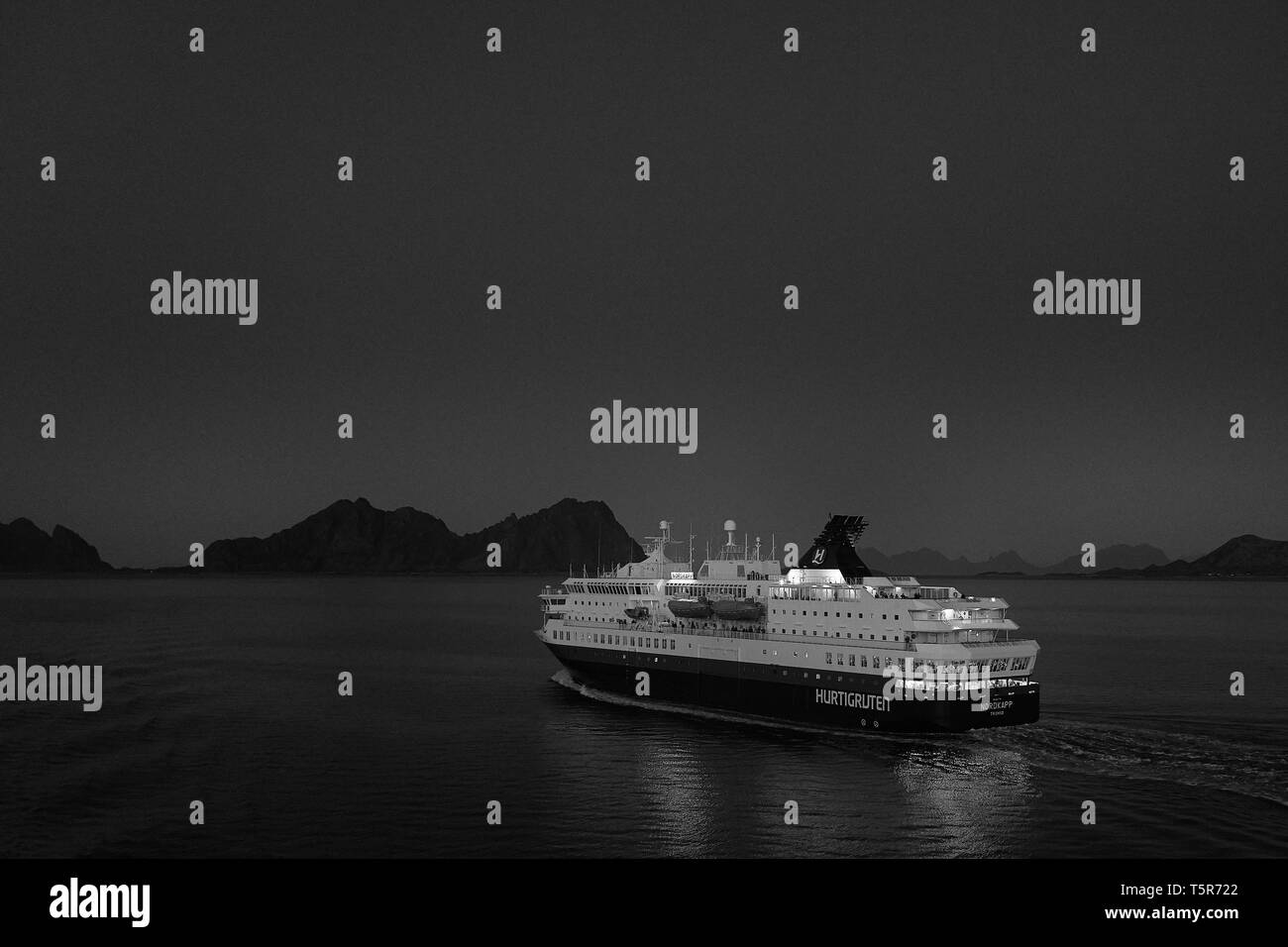 Schwarz-weiß-Foto des norwegischen Hurtigruten-Schiffs MS Nordkapp, das nachts in Richtung Svolvær im Vestfjord auf den Lofoten-Inseln segelt. Norwegen. Stockfoto