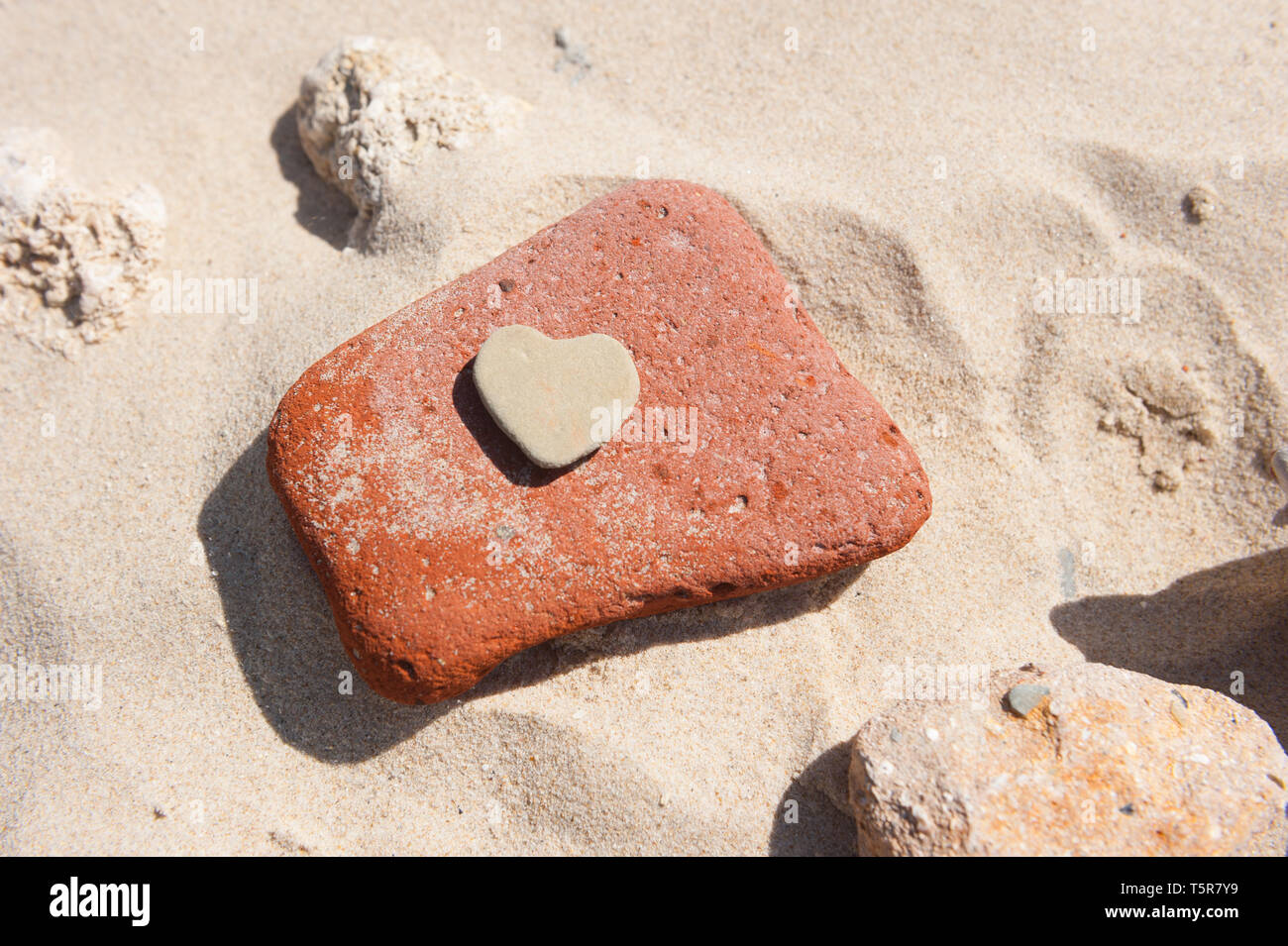 Herz aus Stein auf einem Sandstrand Stockfoto