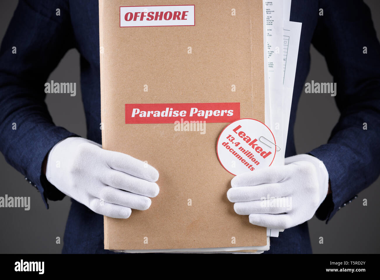 Mann in Anzug und weissen Handschuhen halten Papier Ordner mit dem Paradies Papiere und Offshore Label mit Dokumenten innerhalb, Steuern himmel Dokumente leck Konzept Stockfoto