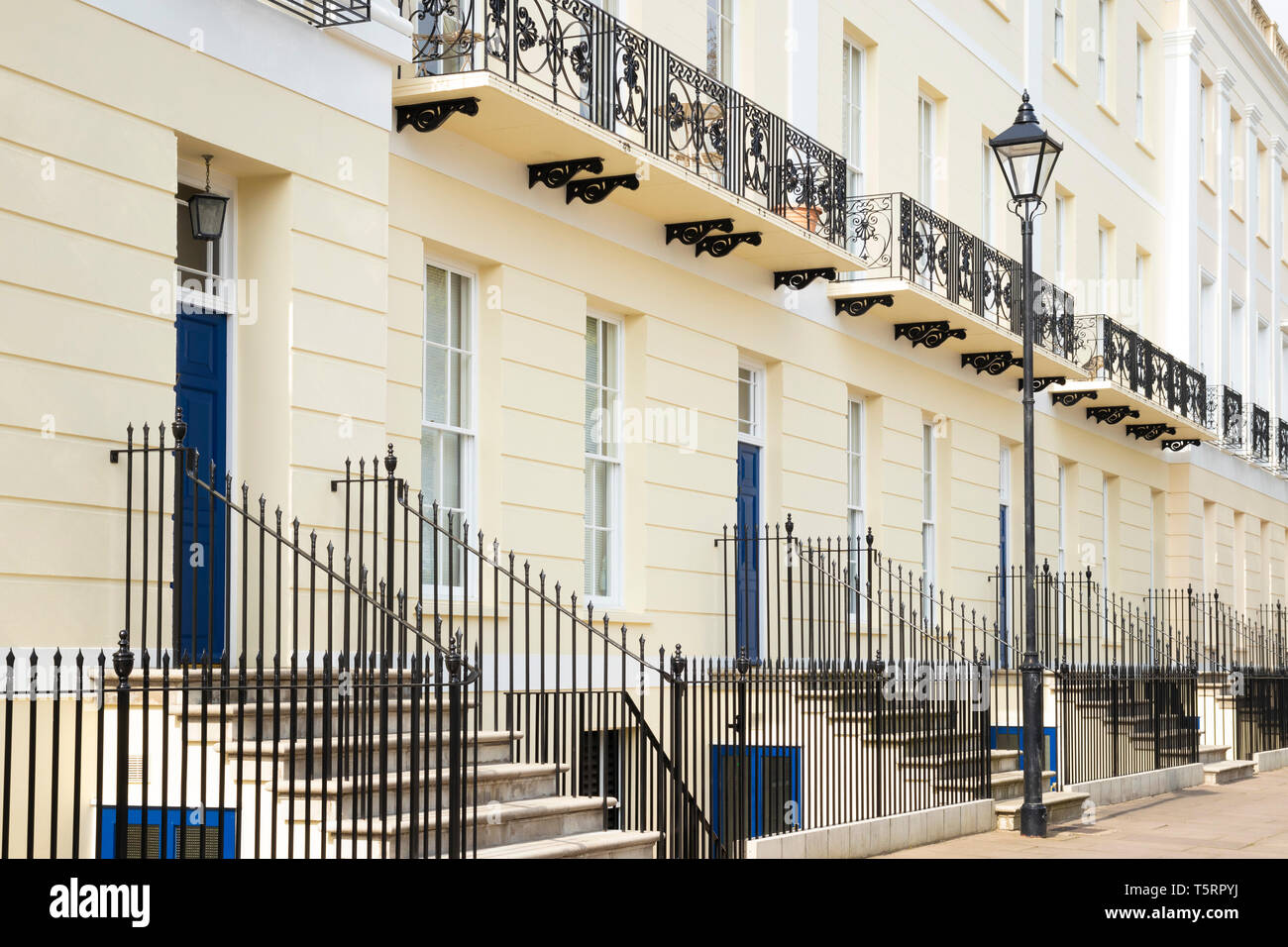 Blaue Türen und schmiedeeiserne Balkone aus Schmiedeeisen auf der Terrasse des georgischen Häuser Imperial Square Cheltenham Spa Gloucestershire England GB UK Europa Stockfoto