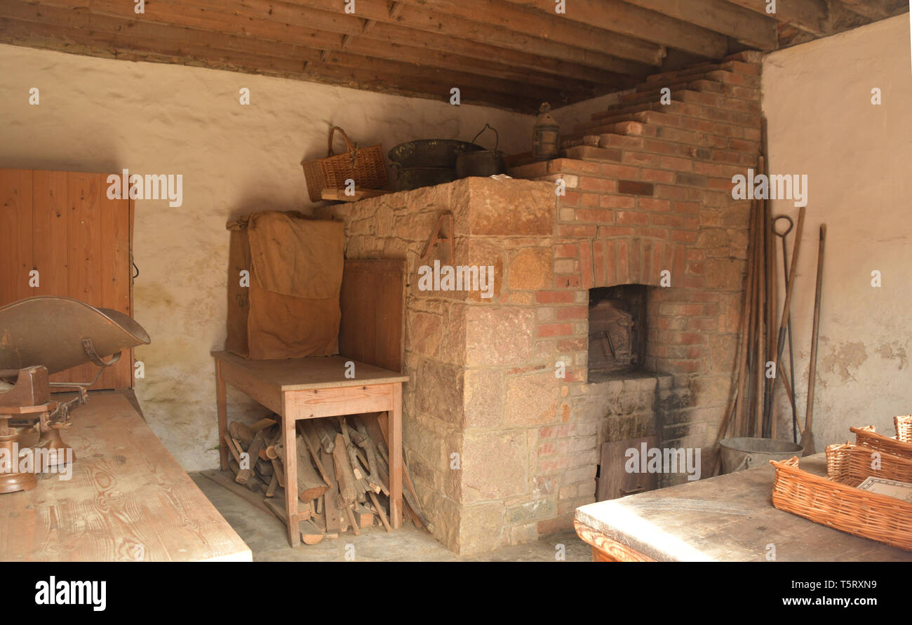 Typische backen Haus mit Brotbackofen, Brennstoff, Holz, Werkzeuge und Waage mit Gewichten und Körbe mit einem Bauernhaus aus dem 18. Jahrhundert im Hampton House Farm Jerse Stockfoto