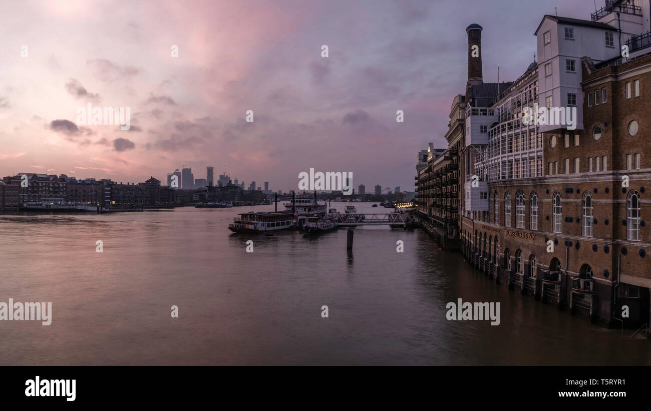 Früh Morgens den Sonnenaufgang in der Nähe der Tower Bridge in London mit Flussblick und Boote an der Themse. Stockfoto