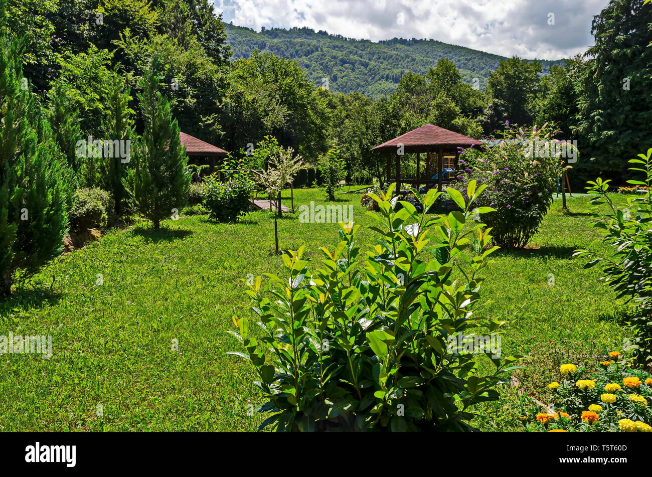 Holz- und Alkoven mit Sitzbank, Tisch mit Kinderspielplatz im Kloster Ort für Entspannung, Balkan, in der Nähe von Varshets Stadt, Bulgarien, Europa Stockfoto