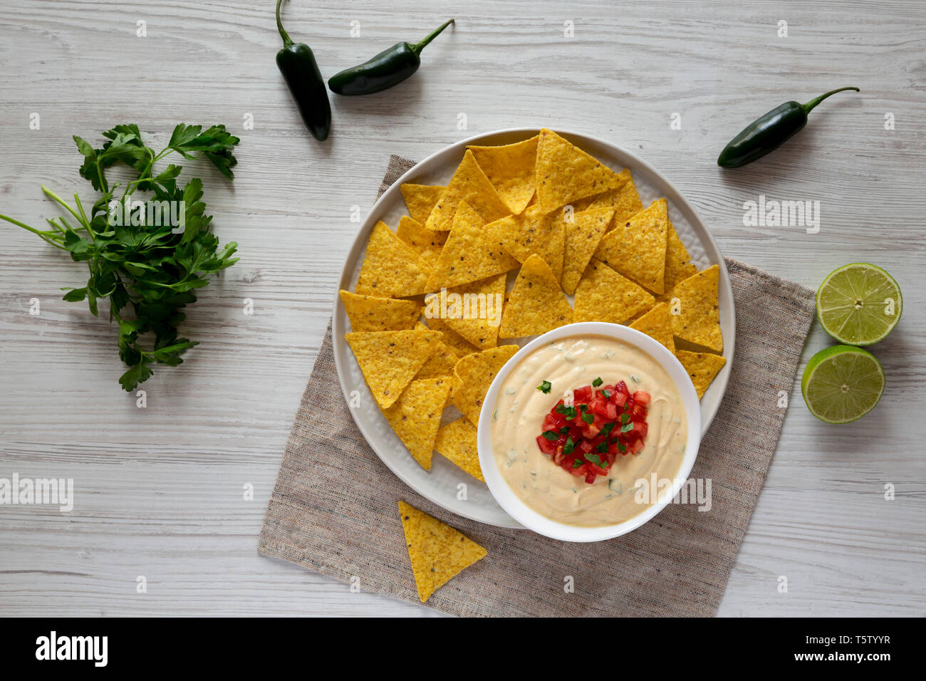 Hausgemachte cheesy Dip zu Nachos mit weißem Holz- Hintergrund. Flach, von oben, Overhead. Stockfoto