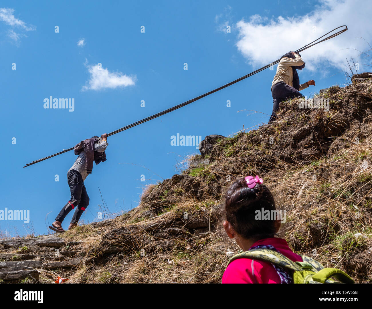 Junge Männer, die vier Meter langen Stahl verstärken Stangen die Punishingly steilen "tausend Schritte weg von Supi zu Khaljuni Uttarakhand Himalaya Stockfoto