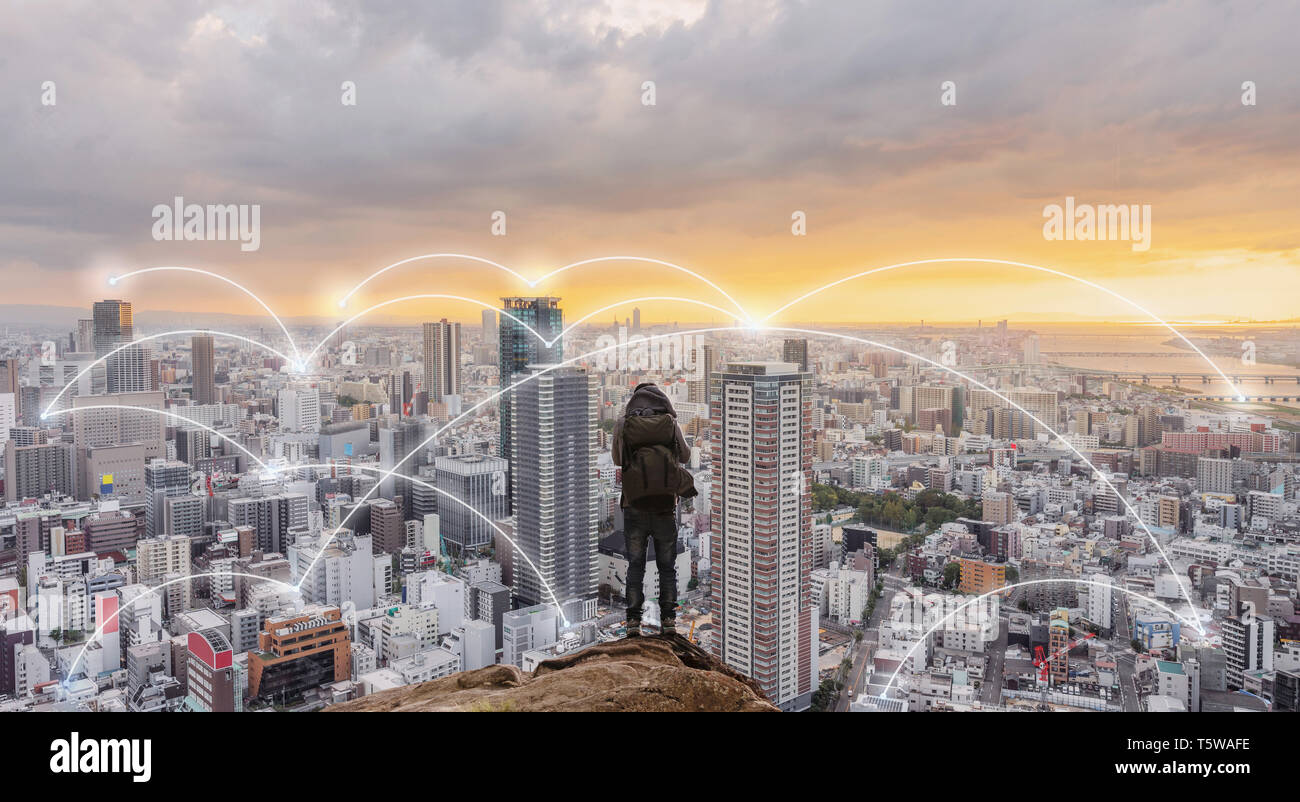 Smart City, das drahtlose Netzwerk und Internet System in der Stadt. Unternehmer stehen auf Berg mit Skyline im Sonnenuntergang Stockfoto
