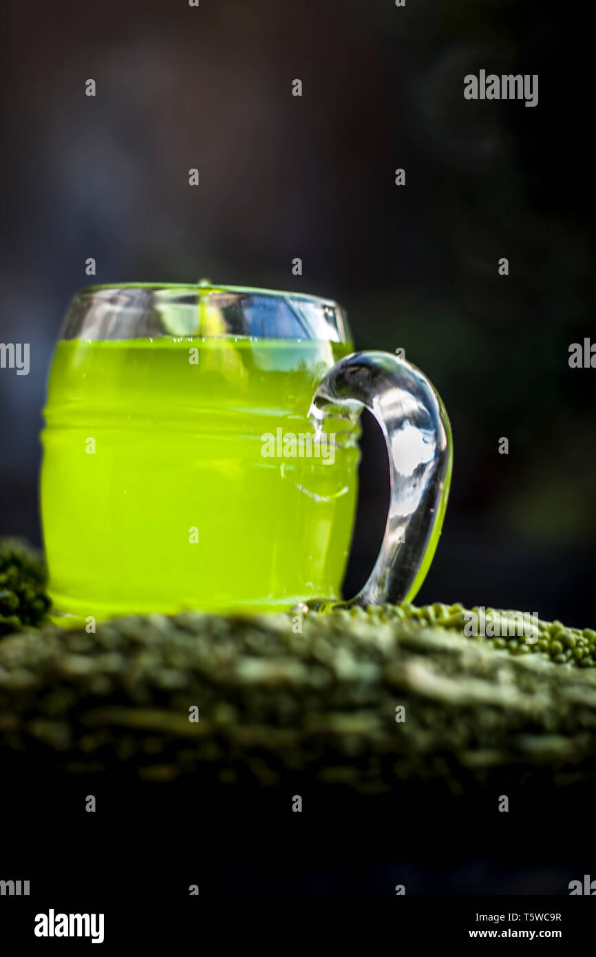 Organische bitteren Kürbis oder bitter Melone oder bitter Squash oder balsam Birnensaft oder Kerala ka Saft in ein transparentes Glas auf Holz- Oberfläche mit raw-org Stockfoto