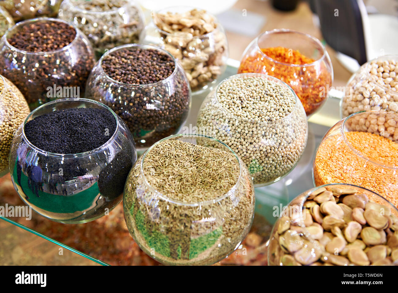 Gewürze schwarze und weiße Pfefferkörner und Kreuzkümmel in Glas runde Gläser im Store. Stockfoto