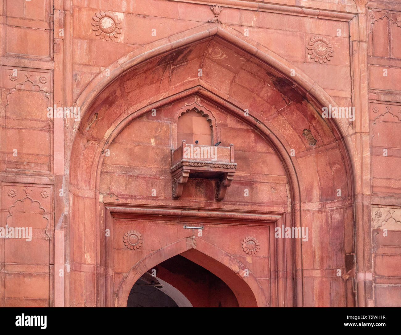 Detail der kunstvoll geschnitzten aus rotem Sandstein gewölbten Eingang mit relief Dekoration der Lahori Tor der Red Fort in Delhi Indien Stockfoto