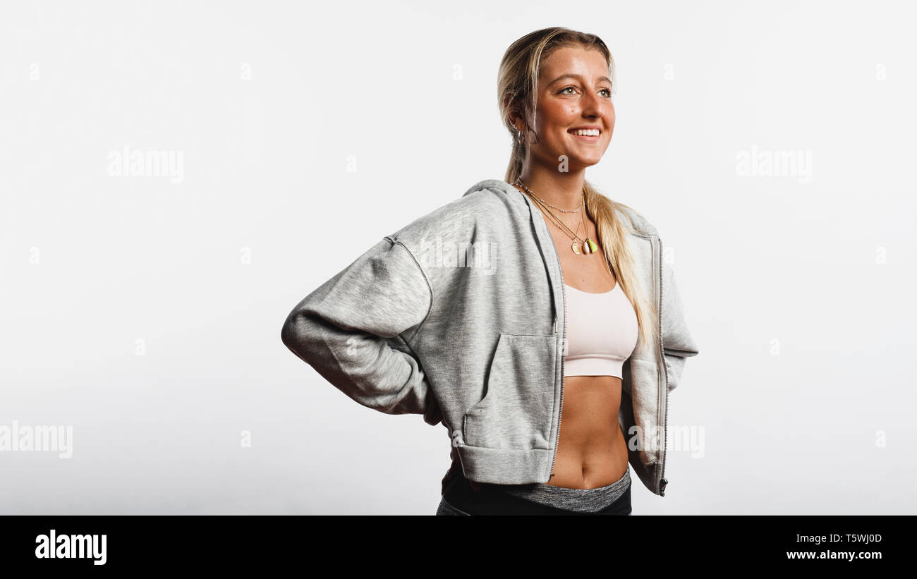Portrait von lächelnden fitness Frau gegen weißen Hintergrund auf den Bund. Lächelnde Frau Athleten mit Eine gebräunte Haut weg suchen. Stockfoto