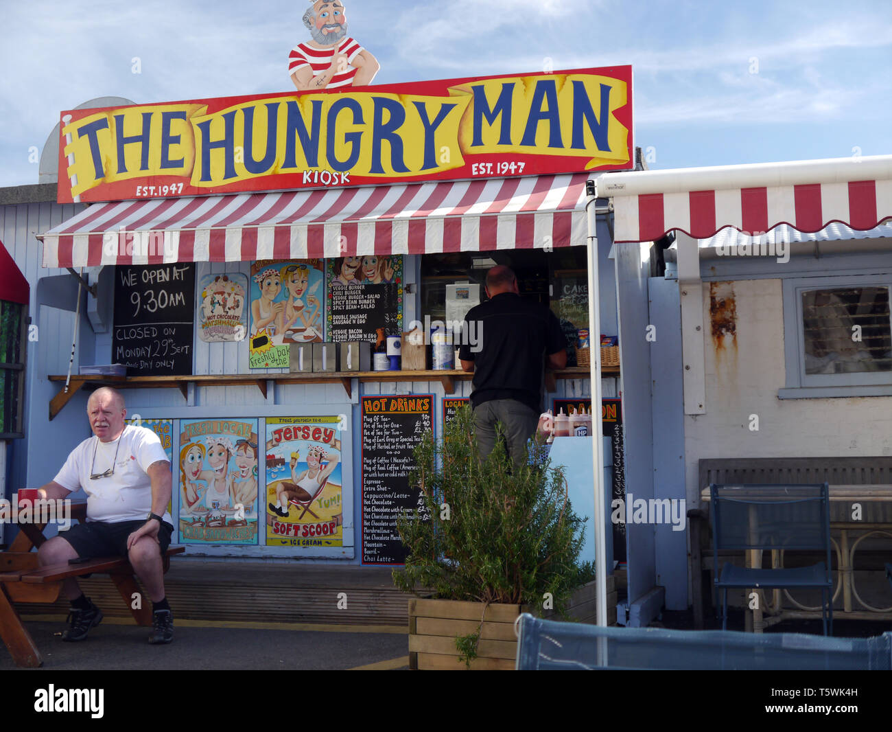 Zwei Männer außerhalb der hungrigen Mann Café Kiosk am Kai in Rozel Bay Harbour auf der Insel Jersey, Channel Isles, UK. Stockfoto