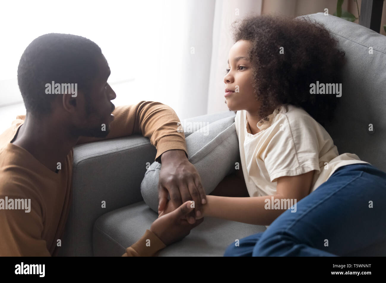 Vater halten Hand kleine Tochter liegend auf dem Sofa unwohl fühlt Stockfoto