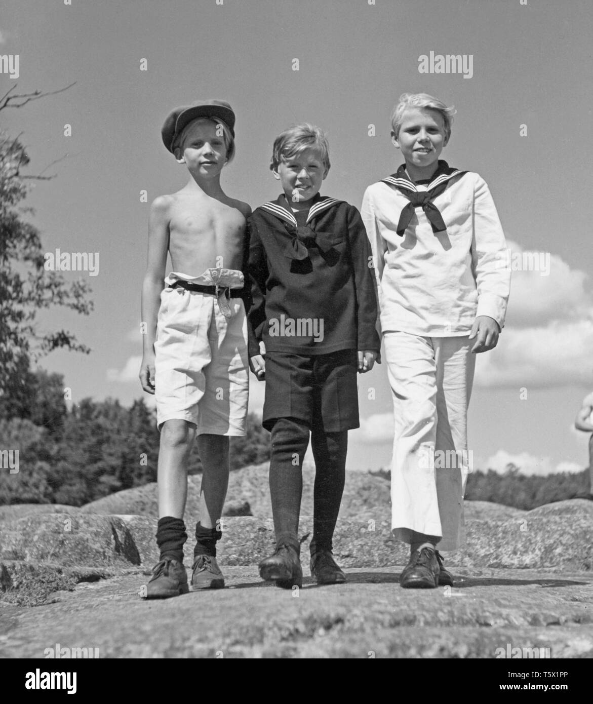 Jungen, die in den 1940er Jahren. Drei junge Jungen zusammen an einem Sommertag. In der Regel in Matrosen Outfit mit gestreiftem Kragen gekleidet. Sie sind Extras auf einen Film set 1945. Schweden. Kristoffersson P50-1 Stockfoto