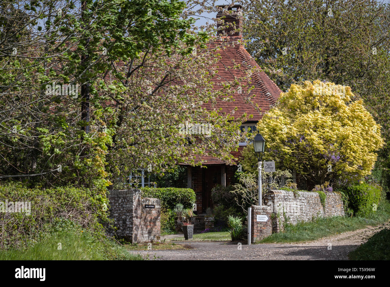 Gemütliche englische Landhaus umgeben von Bäumen Stockfoto