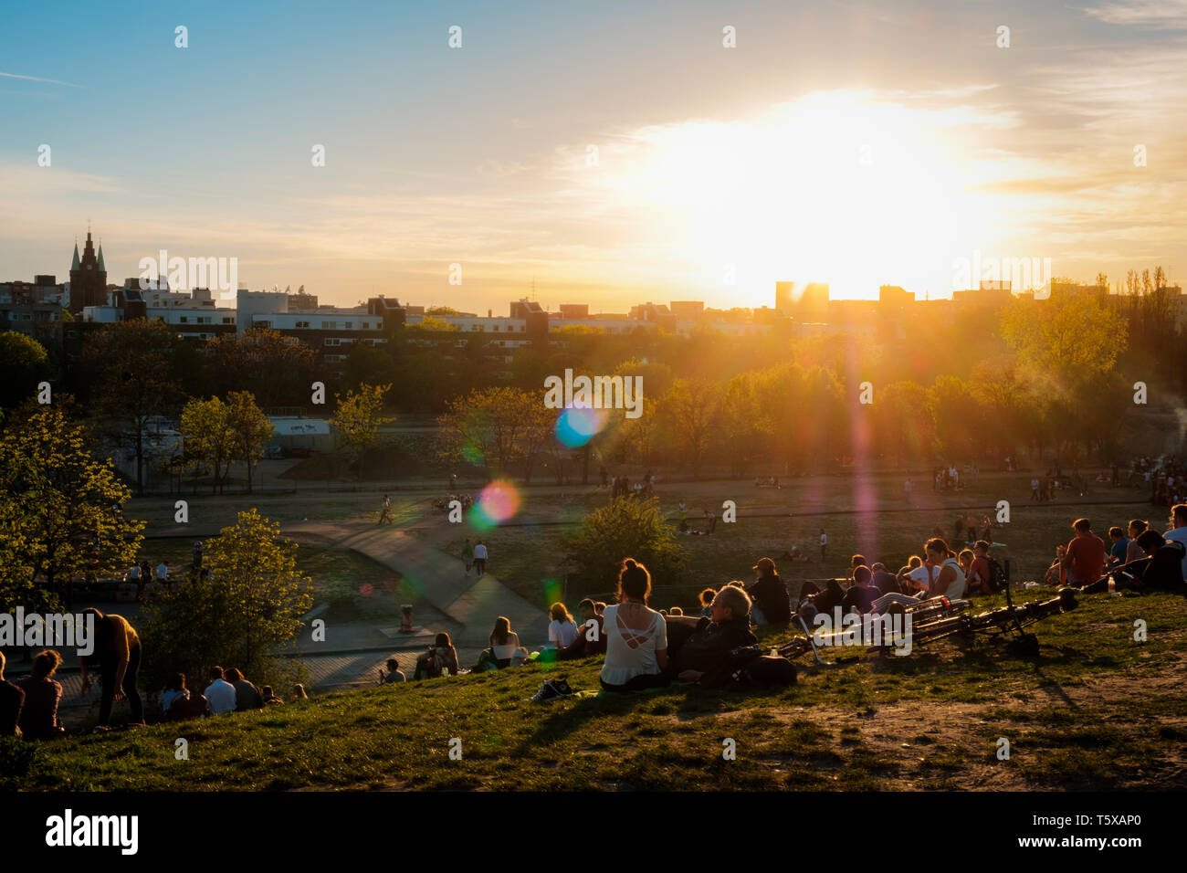 Berlin, Deutschland - April 2019: Personen, die Aussicht auf den Sonnenuntergang Himmel über Skyline von öffentlichen Park (Mauerpark) auf Summer Day in Berlin Stockfoto