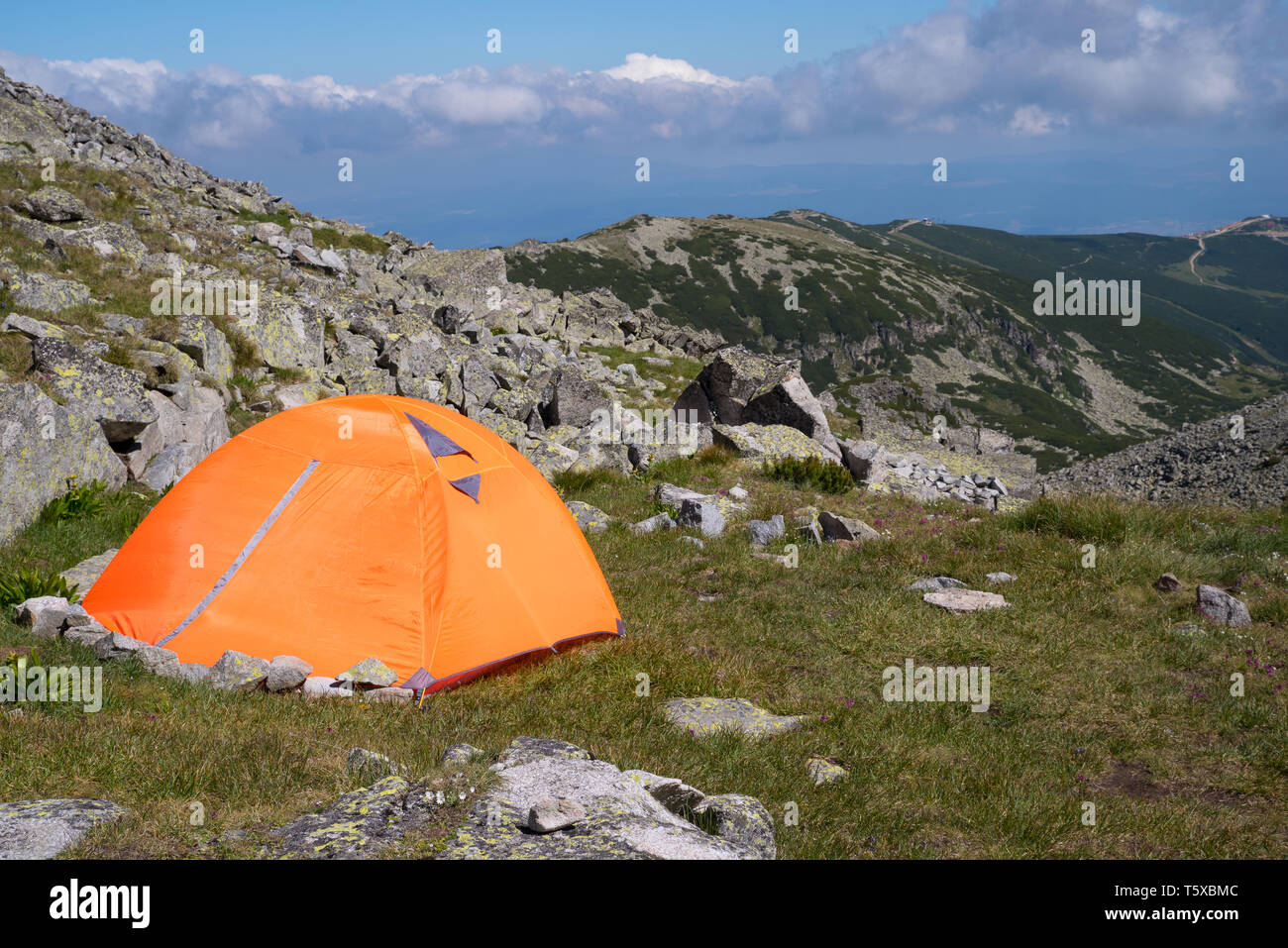 Camping in den Bergen. Orange touristische Hütte. Stockfoto