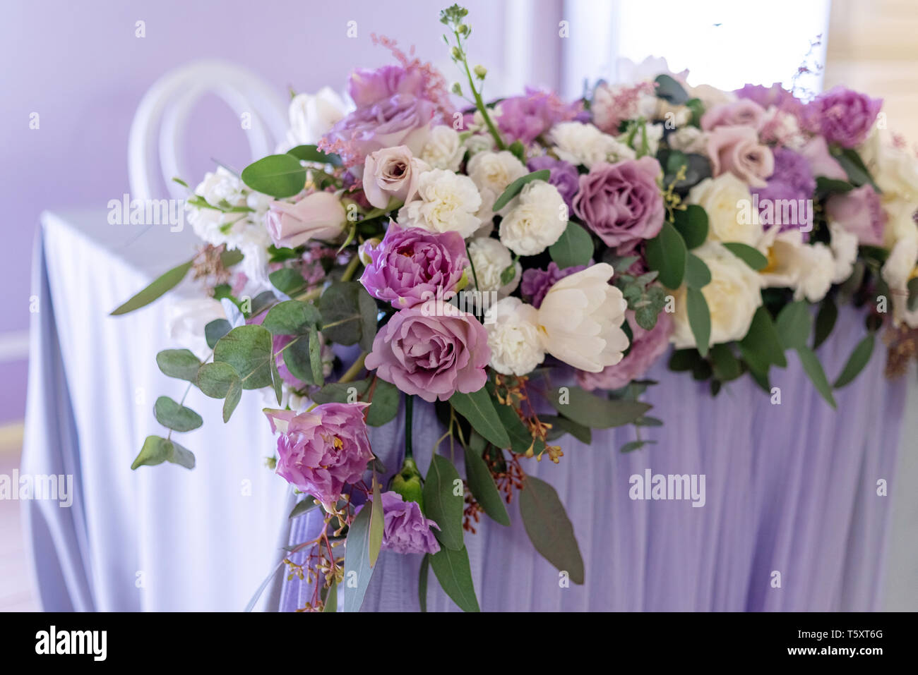 Big Band Komposition aus frischen Blumen und Grünen auf eine Tabelle der Bräutigam und die Braut. Hochzeit Floristik mit Schwerpunkt auf lila Blumen Stockfoto