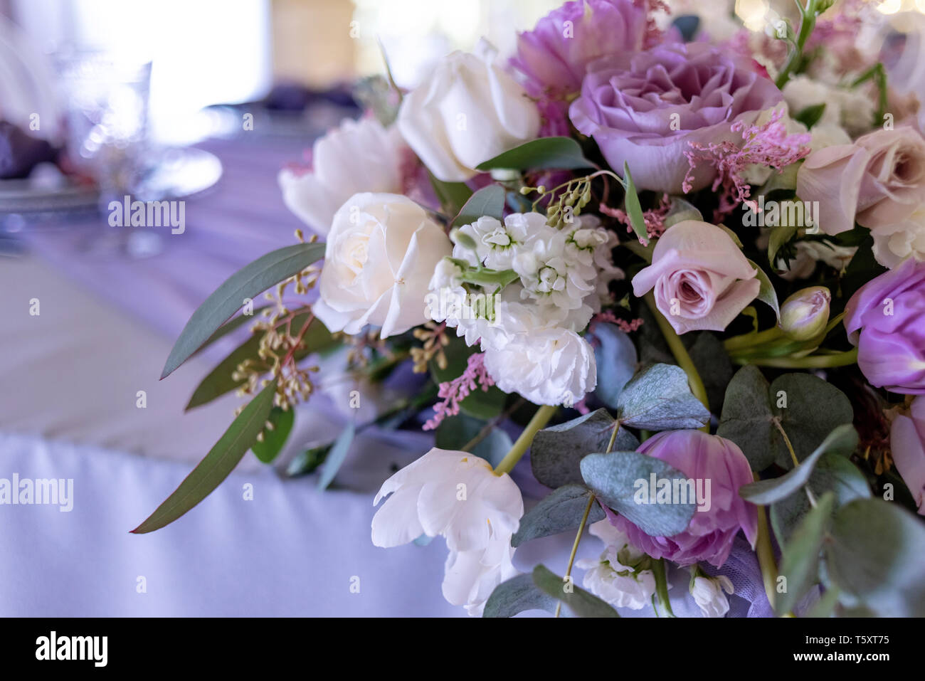 Big Band Komposition aus frischen Blumen und Grünen auf eine Tabelle der Bräutigam und die Braut. Hochzeit Floristik mit Schwerpunkt auf lila Blumen Stockfoto