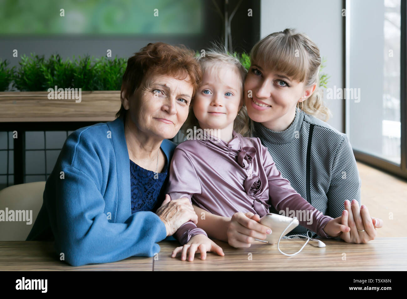 Drei Generationen von Frauen, Großmutter, Tochter und Enkelin aus dem Fenster schauen und Träumen Stockfoto