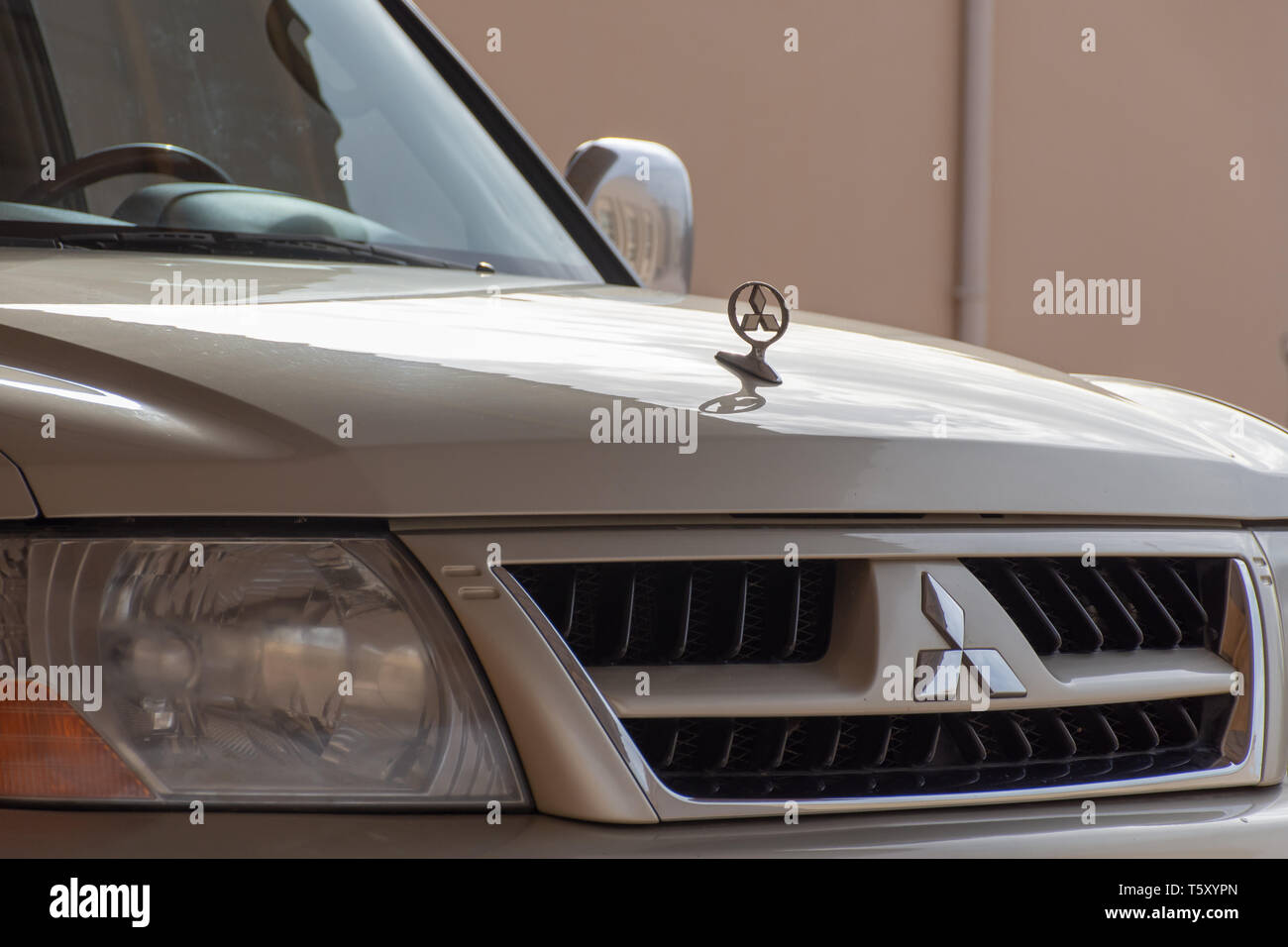 "Nördlichen Emirat, RAK/VAE - 3/30/2019: "einem Mitsubishi Pajero Innenraum geschossen von Schwarzes Lenkrad und Logo." / 2019: "Eine beige Mitsubishi Pajero vorne g Stockfoto
