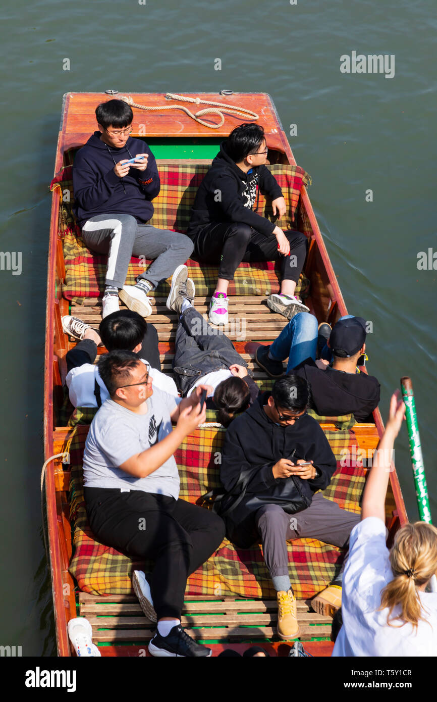 Chinesische orientalische Touristen in einem Punt auf dem Fluss Cam. Universitätsstadt Cambridge, Cambridgeshire, England Stockfoto