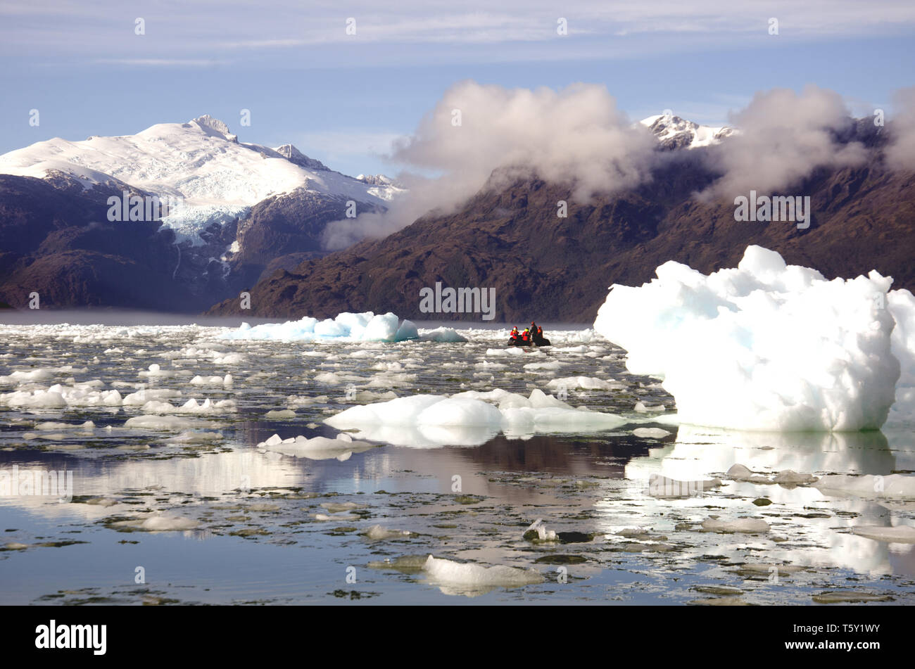 In Falcon Fjord, Chile, ein Zodiac nvaigates unter brash Eis Stockfoto
