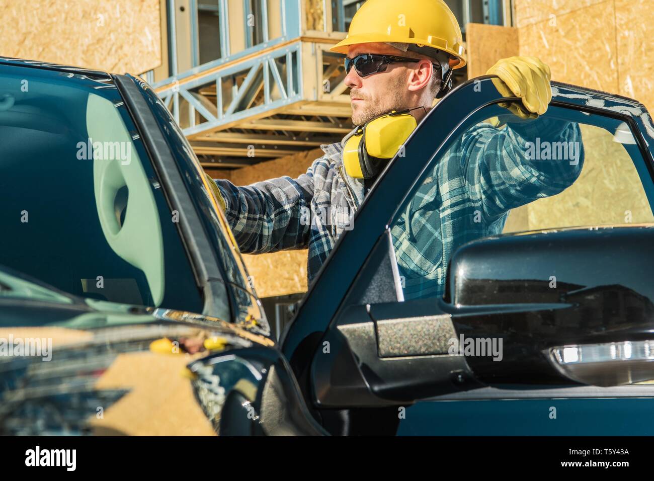 Bau Unternehmen Eigentümer. Kaukasische Supervisor in seinem 30s tragen gelbe harten Hut und seine Firma Pickup Truck. Stockfoto