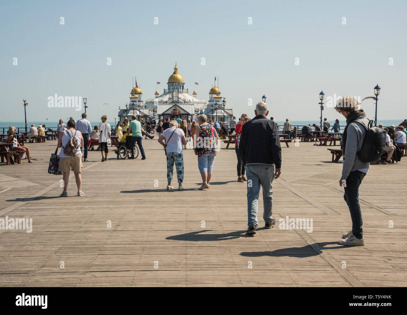 Die Menschen genießen einen Spaziergang entlang der Küste von Eastbourne Pier an einem warmen sonnigen Urlaub entlang der Küste von East Sussex England Großbritannien Stockfoto