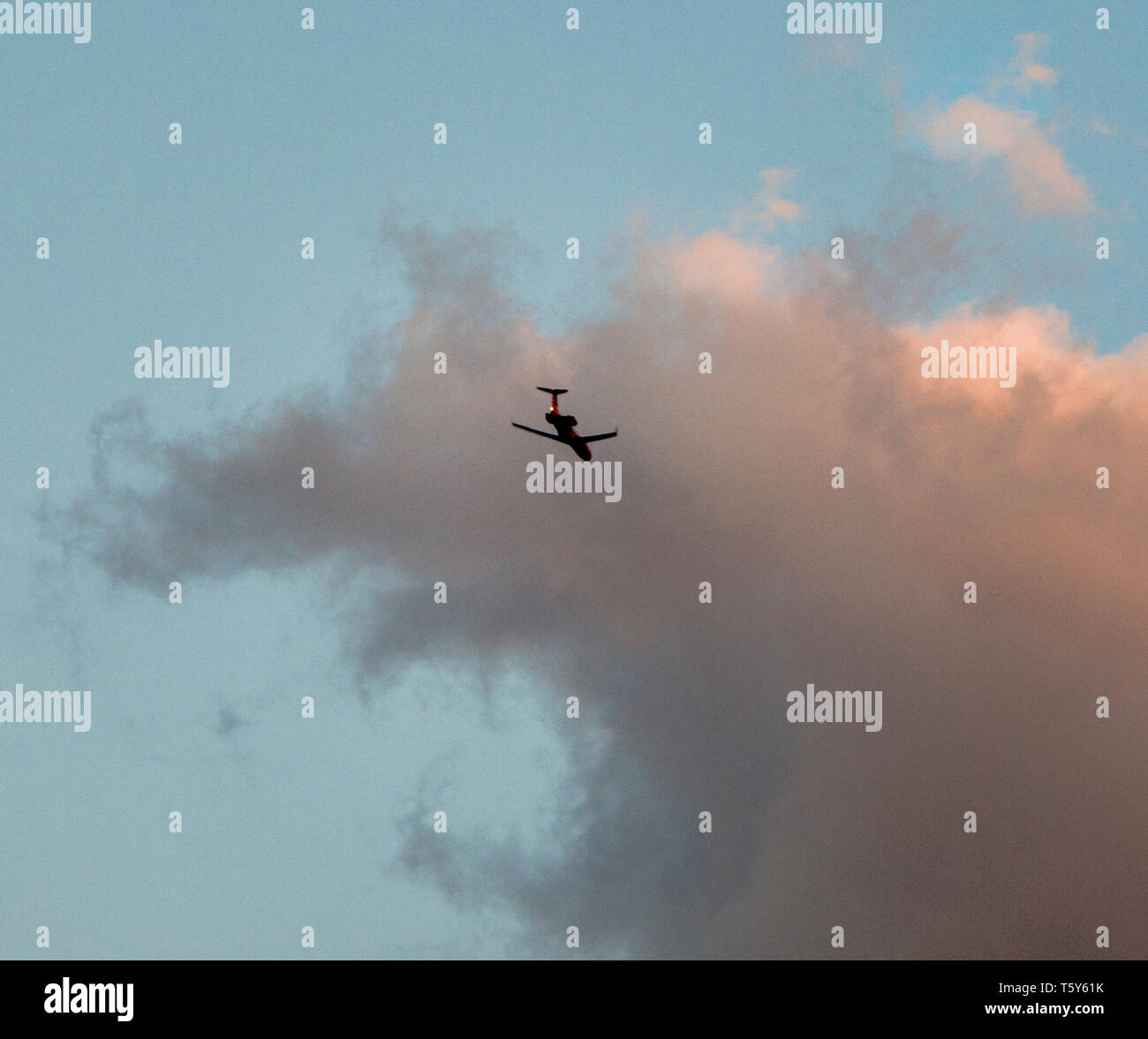 Flugzeug in den Himmel mit warmem Licht auf einer Wolke am Ende des Tages Stockfoto