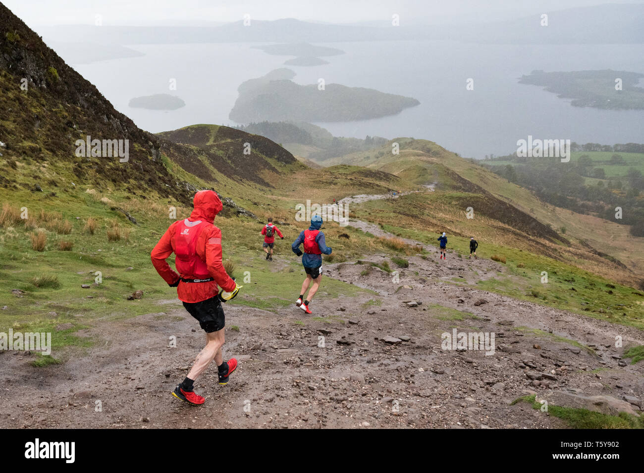 Conic Hill, Loch Lomond, Schottland, Großbritannien - 27 April 2019: Großbritannien Wetter - sehr schwere Duschen teilweise verdecken den Blick über Loch Lomond für Ultra Marathon Läufer absteigend Conic Hill in den frühen Phasen der 53 mile Highland Fling Rennen. Die beschwerliche Ultra Marathon Trail Rennen folgt dem Pfad der West Highland Way durch Loch Lomond und der Trossachs National Park zwischen Milngavie und Tyndrum. Credit: Kay Roxby/Alamy leben Nachrichten Stockfoto