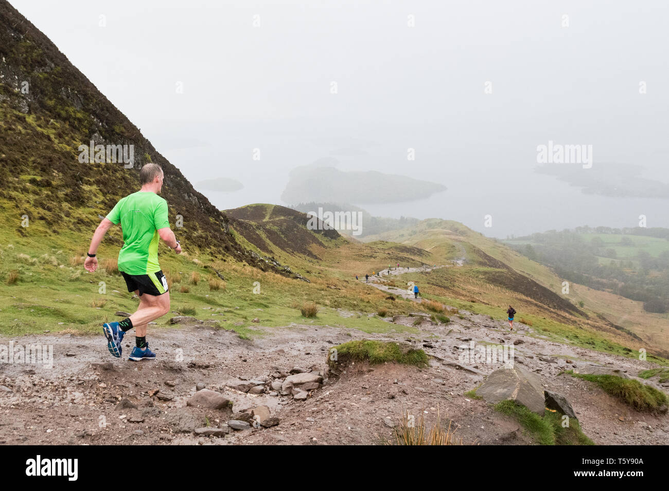 Conic Hill, Loch Lomond, Schottland, Großbritannien - 27 April 2019: Großbritannien Wetter - sehr schwere Duschen teilweise verdecken den Blick über Loch Lomond für Ultra Marathon Läufer absteigend Conic Hill in den frühen Phasen der 53 mile Highland Fling Rennen. Die beschwerliche Ultra Marathon Trail Rennen folgt dem Pfad der West Highland Way durch Loch Lomond und der Trossachs National Park zwischen Milngavie und Tyndrum. Credit: Kay Roxby/Alamy leben Nachrichten Stockfoto