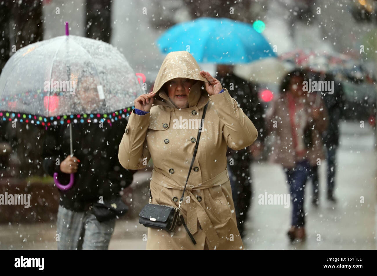 Chicago, USA. 27 Apr, 2019. Menschen gehen inmitten von Schnee in der Innenstadt von Chicago, USA, am 27. April 2019. Eine seltene spät Schneesturm fegte über Chicago am Samstag. Credit: Wang Ping/Xinhua/Alamy leben Nachrichten Stockfoto