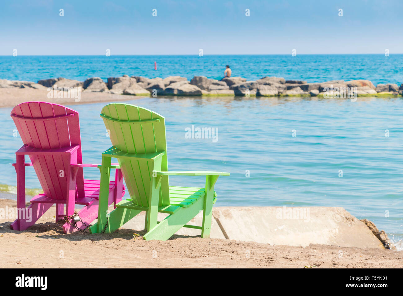 Zwei helle, farbenfrohe Liegestühle am Kew Balmy Beach mit Blick auf den Lake Ontario im Osten von Toronto, Kanada Stockfoto