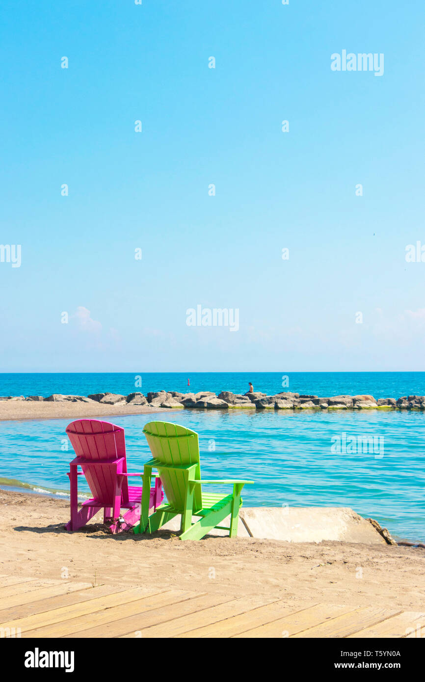 Zwei helle, farbenfrohe Liegestühle am Kew Balmy Beach mit Blick auf den Lake Ontario im Osten von Toronto, Kanada Stockfoto