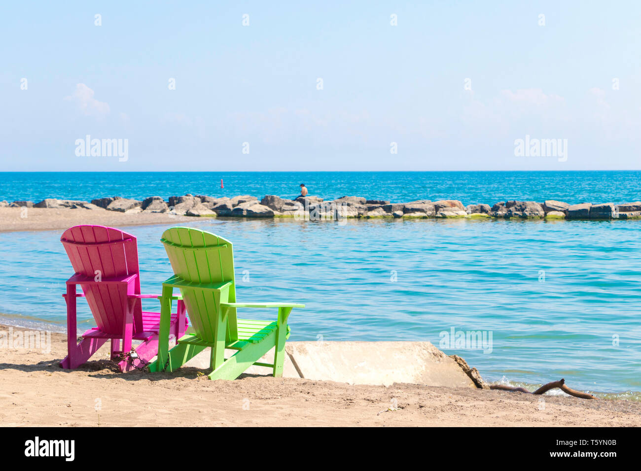 Zwei helle, farbenfrohe Liegestühle am Kew Balmy Beach mit Blick auf den Lake Ontario im Osten von Toronto, Kanada Stockfoto