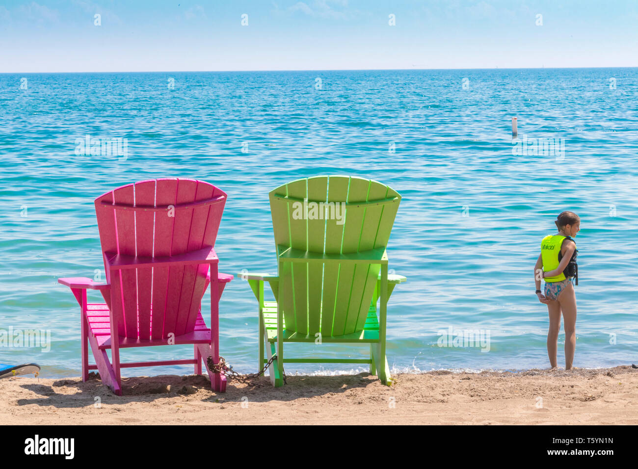 Zwei helle, farbenfrohe Liegestühle am Kew Balmy Beach mit Blick auf den Lake Ontario im Osten von Toronto, Kanada Stockfoto