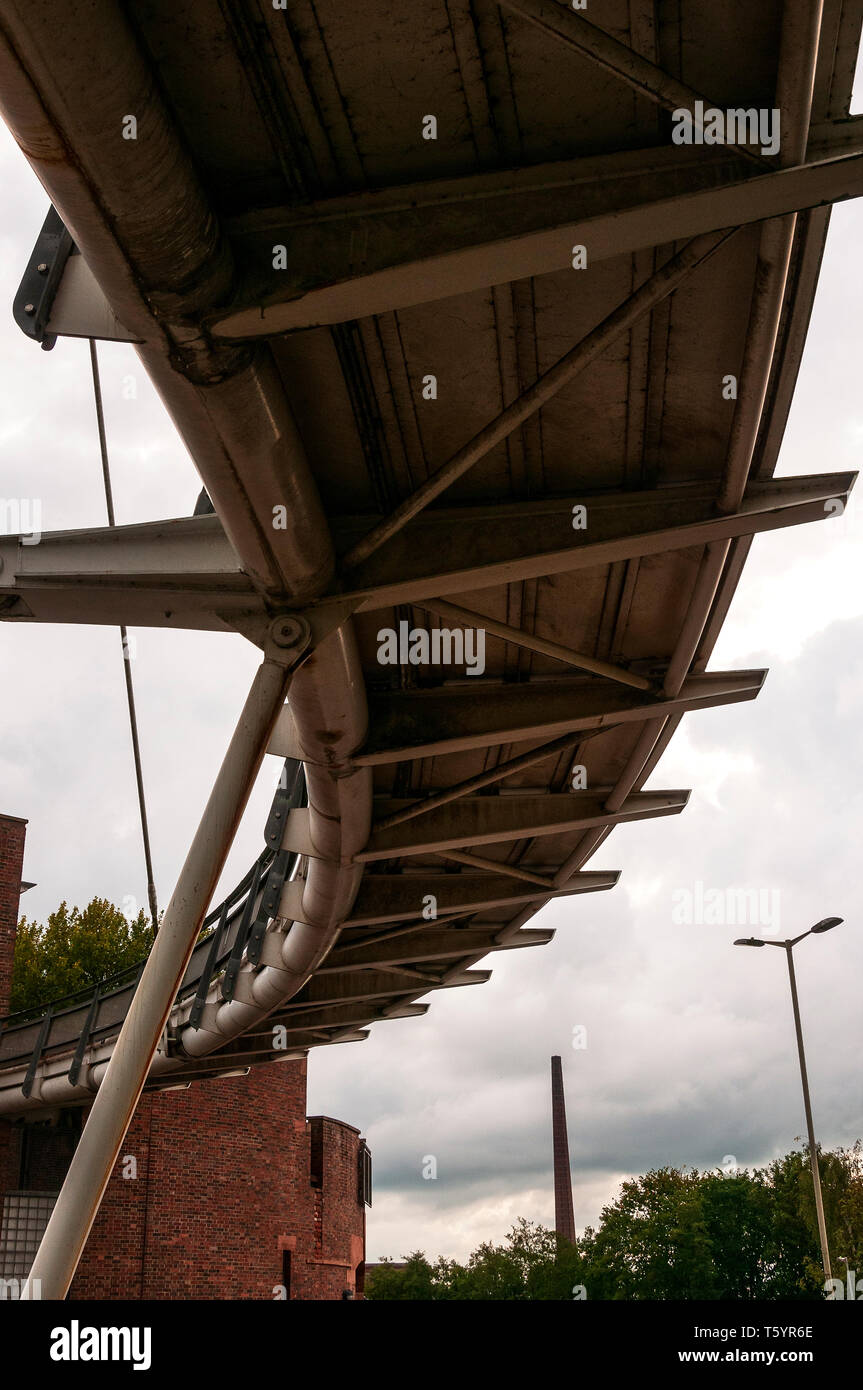 Die unterseite Blick auf die geschwungene gebogene Stahlkonstruktion der Brücke überspannt den beschäftigt eine 595 zu einem modernen Faksimile der Irischen Tor, Carlisle Stockfoto