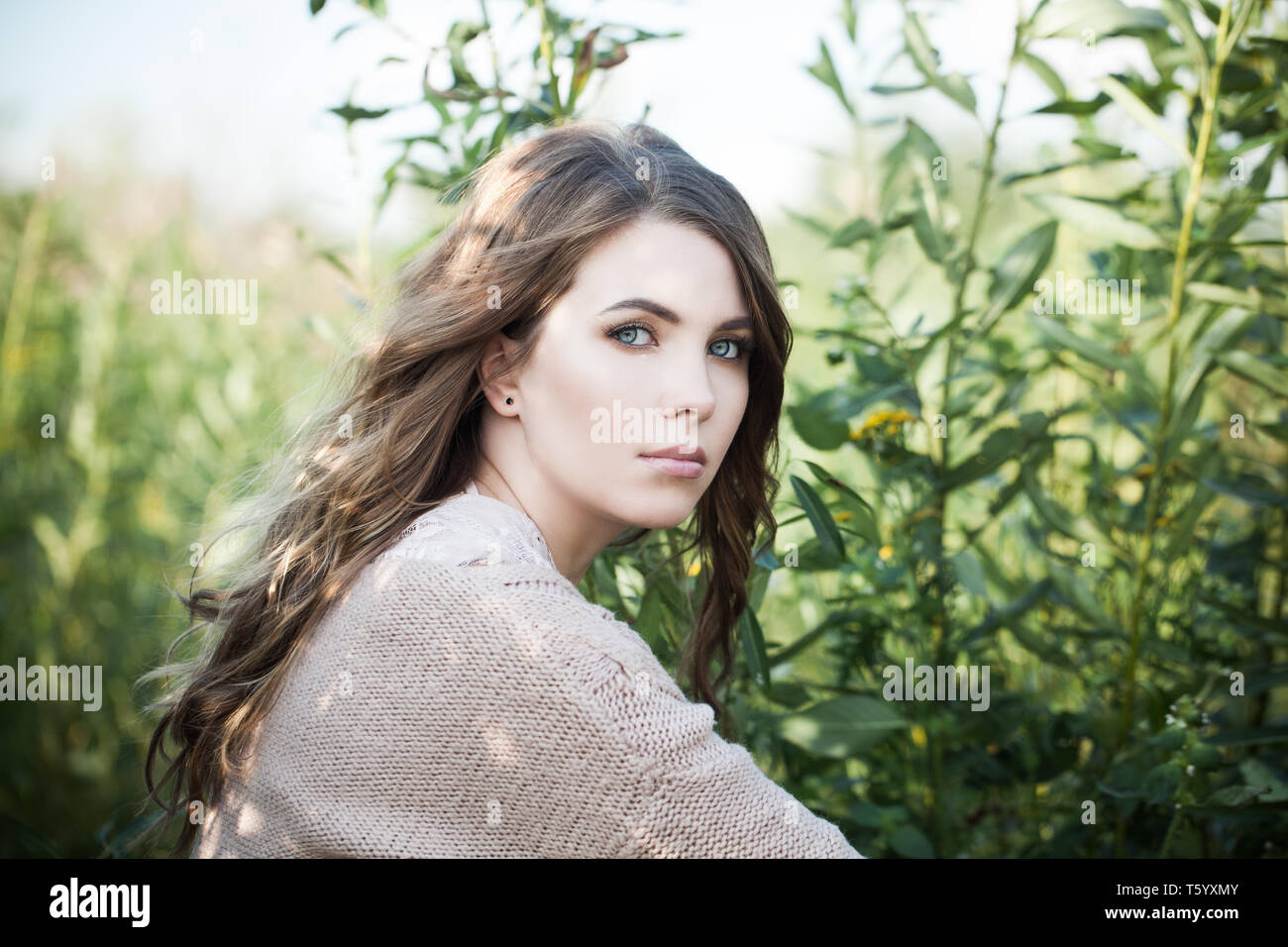 Pretty Woman im Freien. Schöne weibliche model in organischer Baumwolle Pullover auf grünem Gras Hintergrund Stockfoto