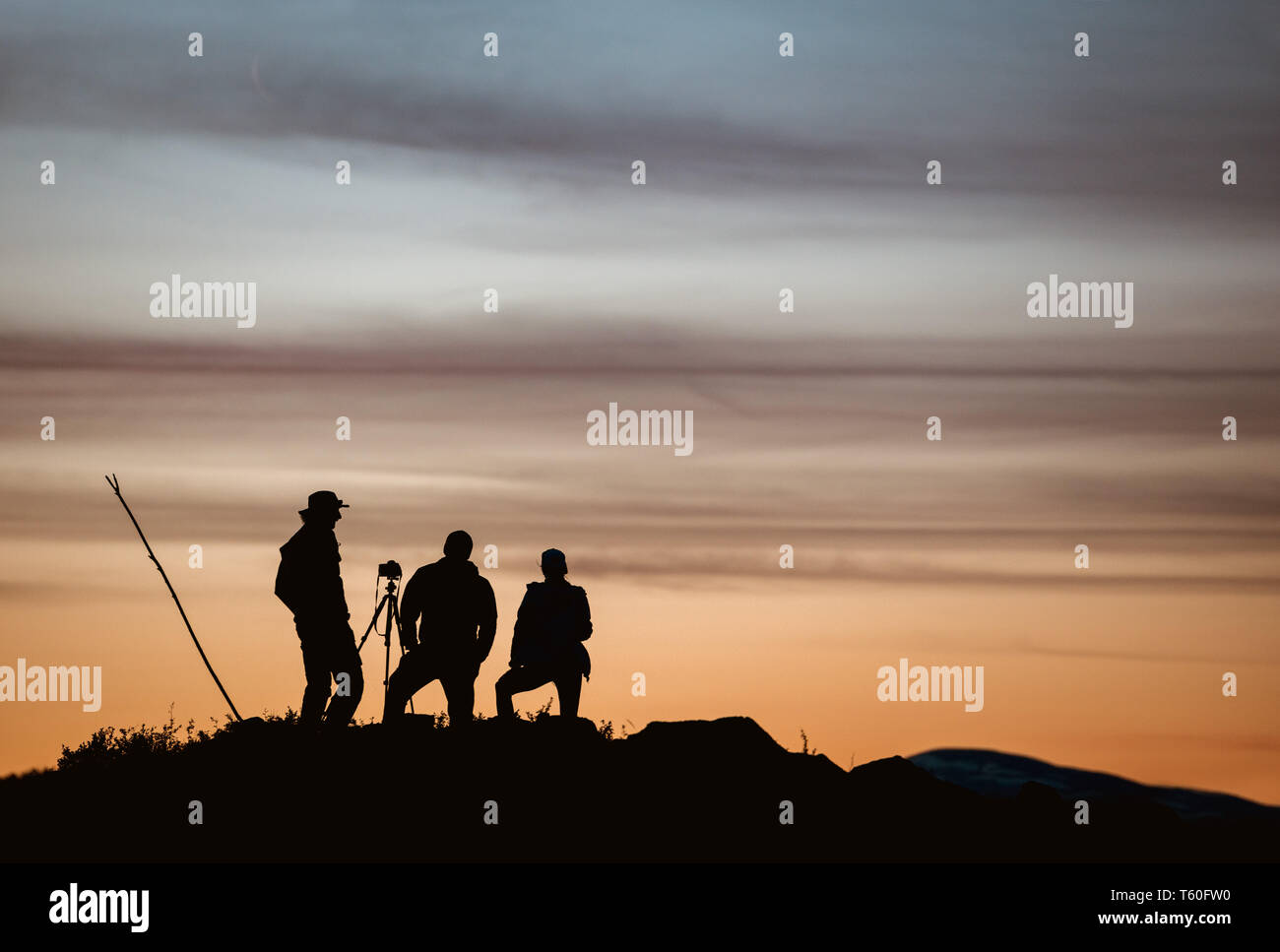 Gruppe von drei Fotografen, Foto gegen Sonnenuntergang Himmel Stockfoto
