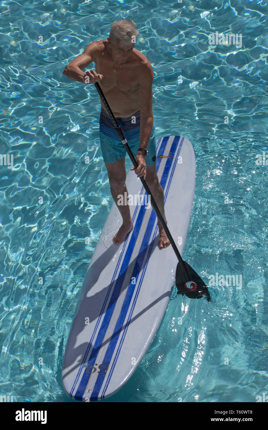 Senior Standup-Surfer in hellblauem klaren Wasser von Ihr Browser kann leider keine eingebetteten Frames - die SUP-Sport als Freizeit Sport alle Altersklassen: Senioren stehen auf SUP Board von oben Stockfoto