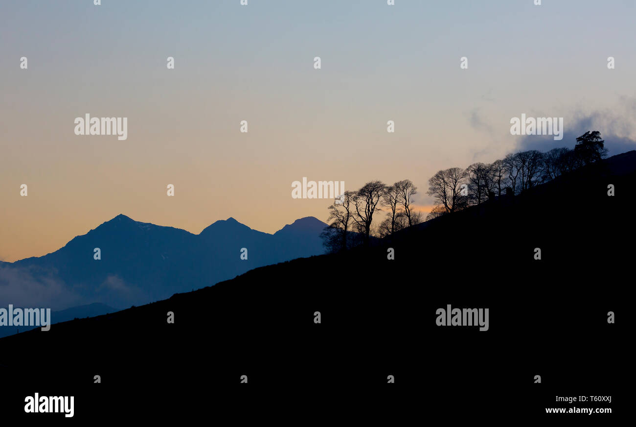 Moody Dämmerung Landschaft mit Silhouetten Blick auf spektakuläre Mount Snowdon & Horseshoe Berggipfel in Reichweite in der Dämmerung, Nord-Wales. Sonnenuntergang in Großbritannien. Stockfoto