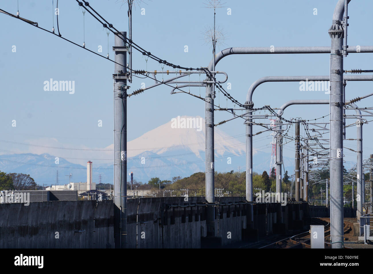 Mount Fuji erscheint in der Abstand zwischen den Linien und Strukturen entlang der Schienen auf dem Tsukuba Express Linie von Moriya Station, Ibaraki gebaut. Stockfoto