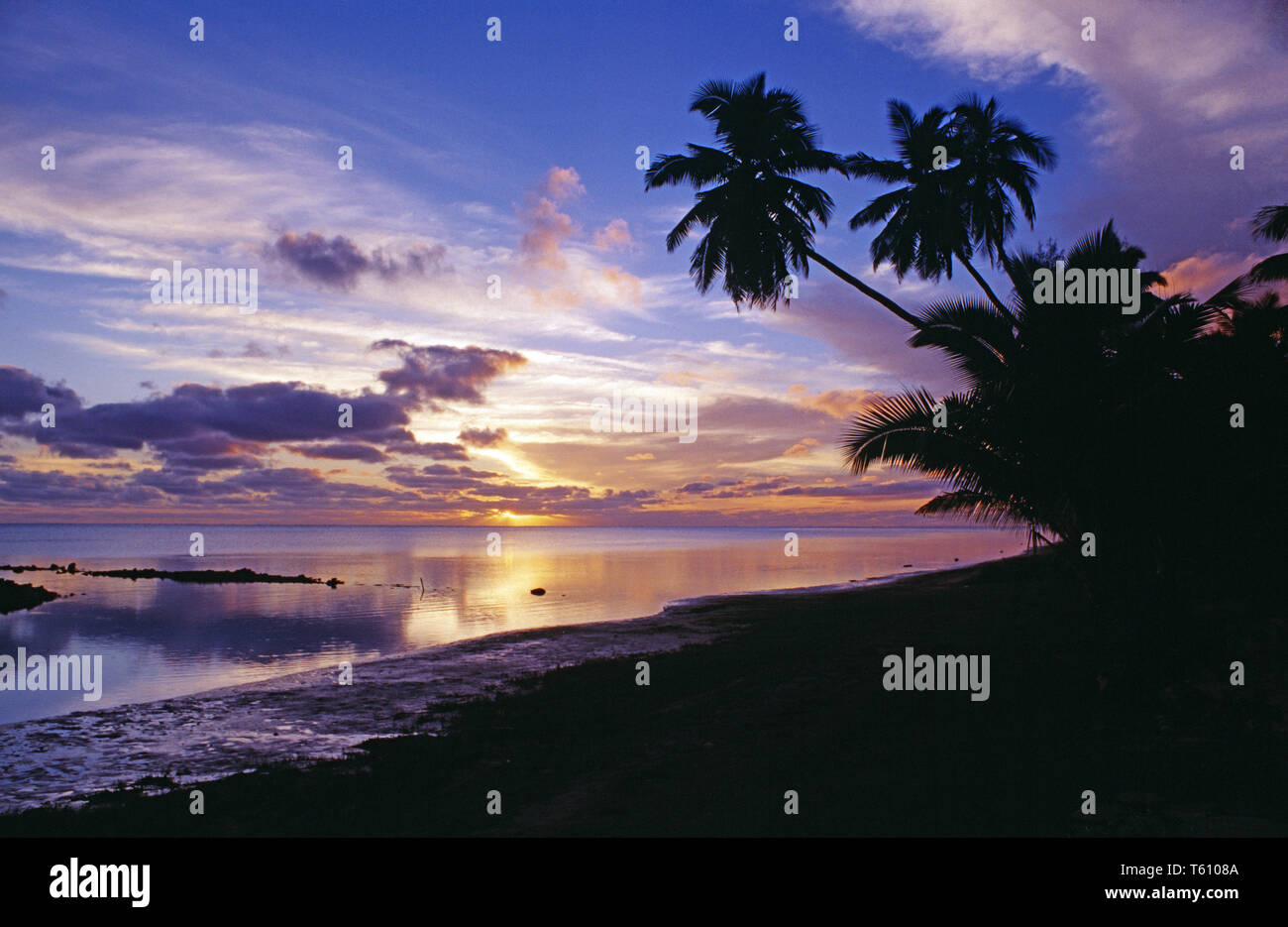 Cook Inseln. Aitutaki. Tropical Beach Sonnenuntergang mit Kokospalmen. Stockfoto