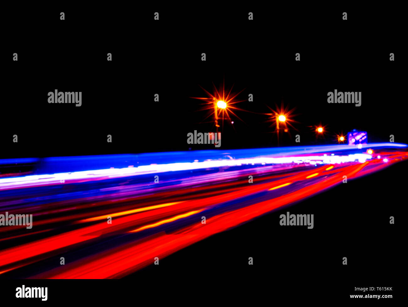 Autos leichte Wanderwege auf einer gekrümmten Autobahn bei Nacht. Traffic Night Trails. Bewegungsunschärfe. Nacht Stadt Straße mit verkehr Scheinwerfer Bewegung. Stadtbild. Leuchten Stockfoto