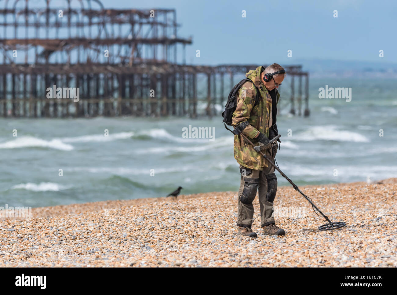 Der Mensch auf der Suche nach Schatz an einem Strand mit einem Metalldetektor in Brighton, East Sussex, England, UK. Stockfoto