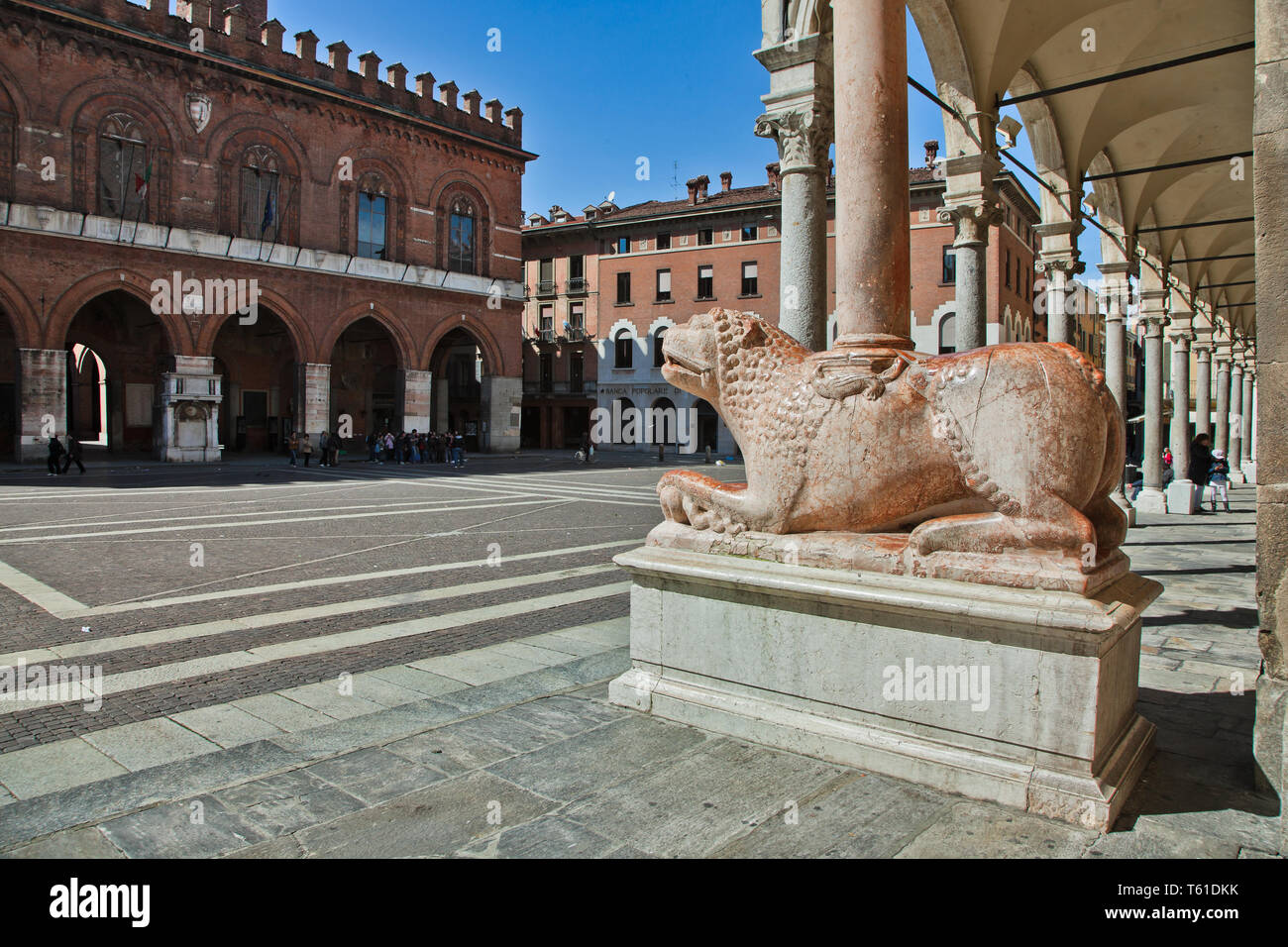 Cremona, Piazza del Comune: uno dei Leoni stilofori del Portale maggiore del Duomo (Oper duecentesca di Giambono da bissone). Sfondo: Il Portico dett Stockfoto