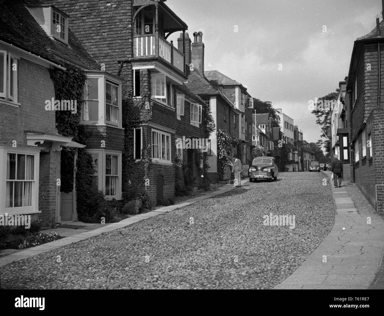 Gepflasterte Straße mit Autos. Amateur Foto von einer Familie auf Urlaub am Meer in England. c 1950. Foto von Tony Henshaw Stockfoto