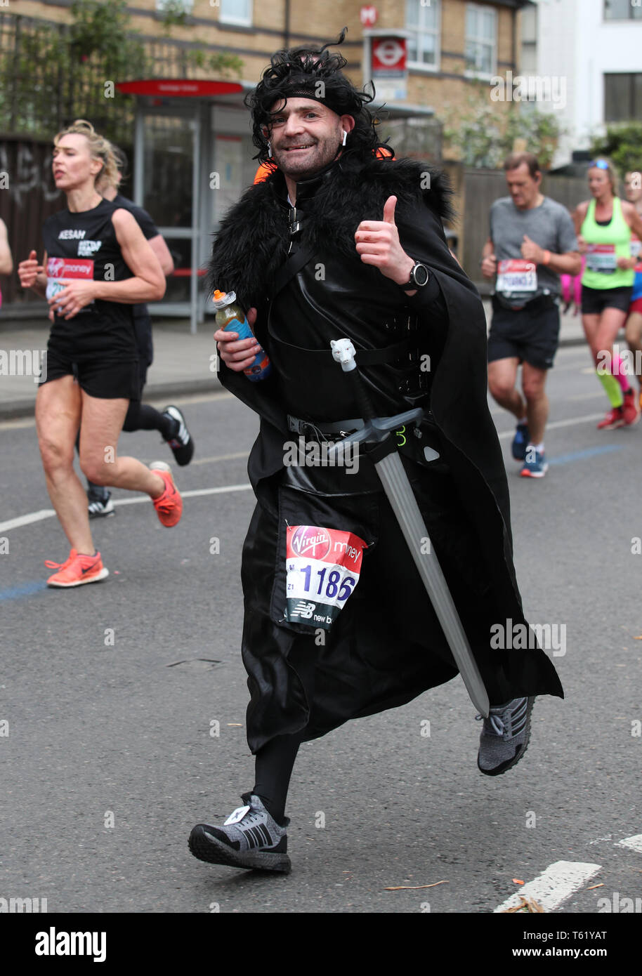 Ein Läufer wie der Charakter Jon Snow von Spiel der Throne während der 2019 Virgin Money London Marathon gekleidet. Stockfoto